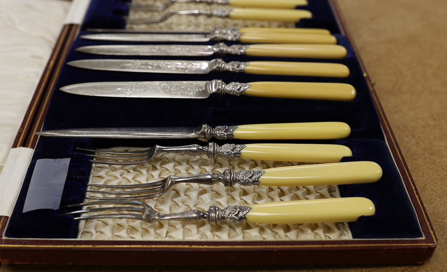 A cased set of six pairs of ivorine handled plated dessert eaters